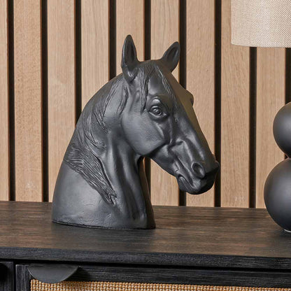 Black metal horse head ornament displayed on a console