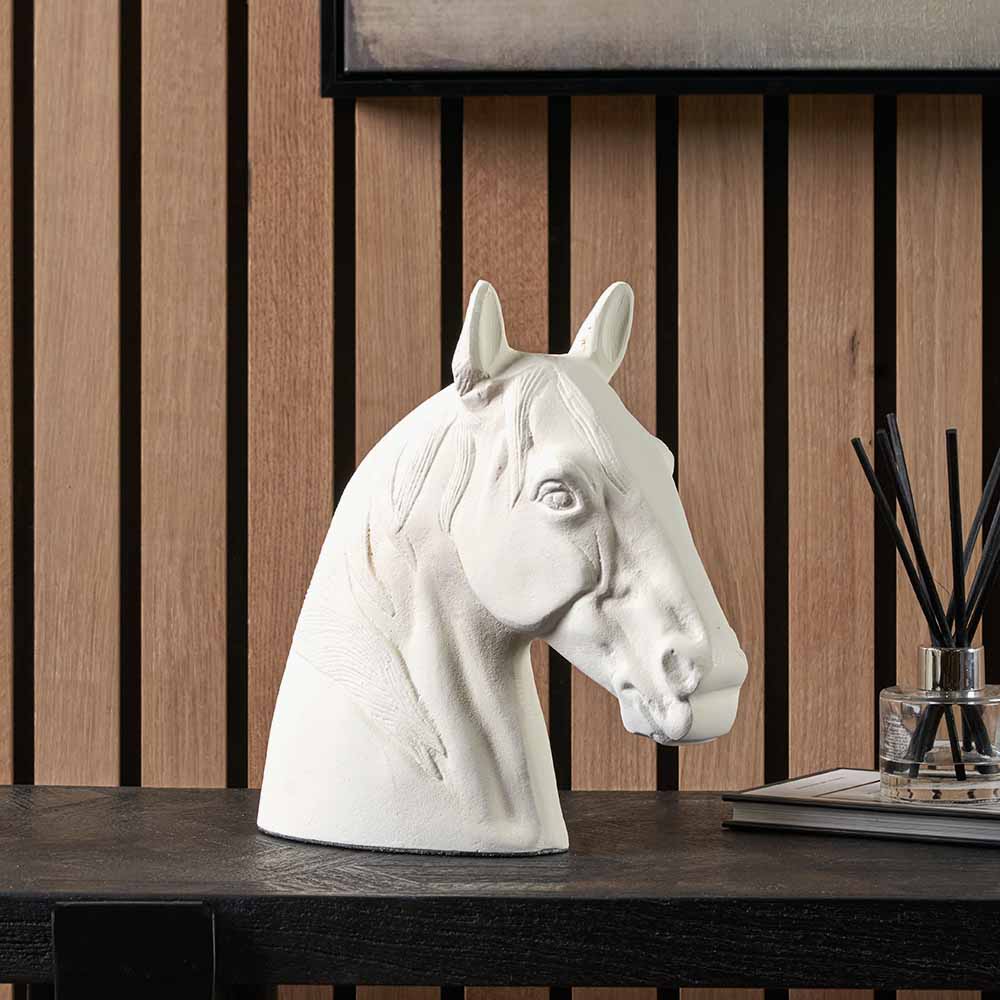 White metal horse head ornament displayed on a console